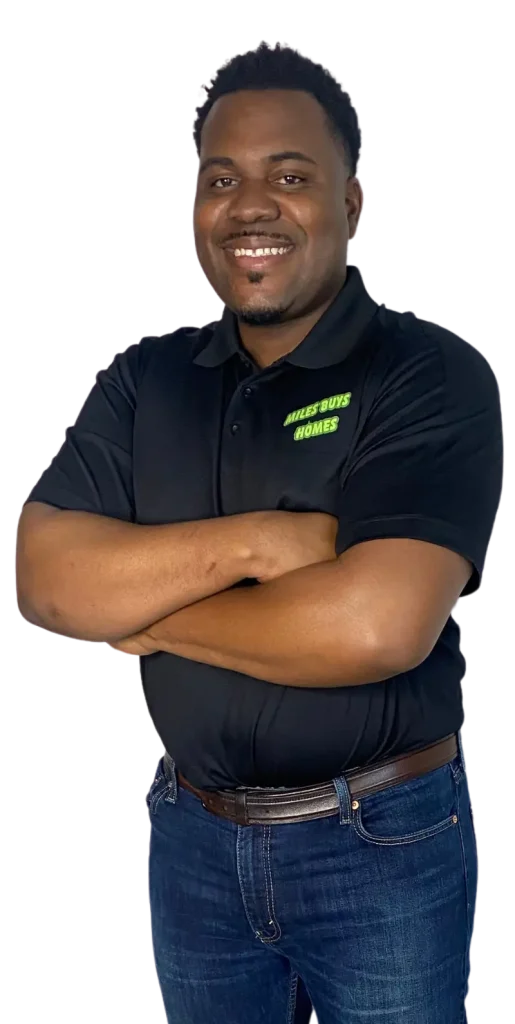 Miles from Miles Buys Homes seated in a branded shirt